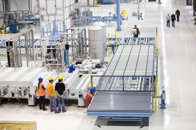 工人们在应用材料公司2010年在西安建的实验室里操作太阳能电池板生产线。