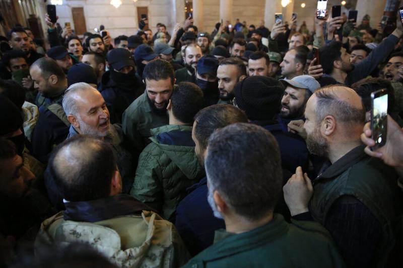 周日,在领导此次进攻的叛军头目戈拉尼(中间左二)在清真寺发表讲话之前,人们与他拍照。