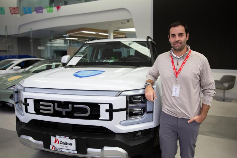 费尔南多·洛佩茲是圣路易斯波多西一家比亚迪经销商的经理,他身后是2025年版的BYD Shark插电式混合动力皮卡。