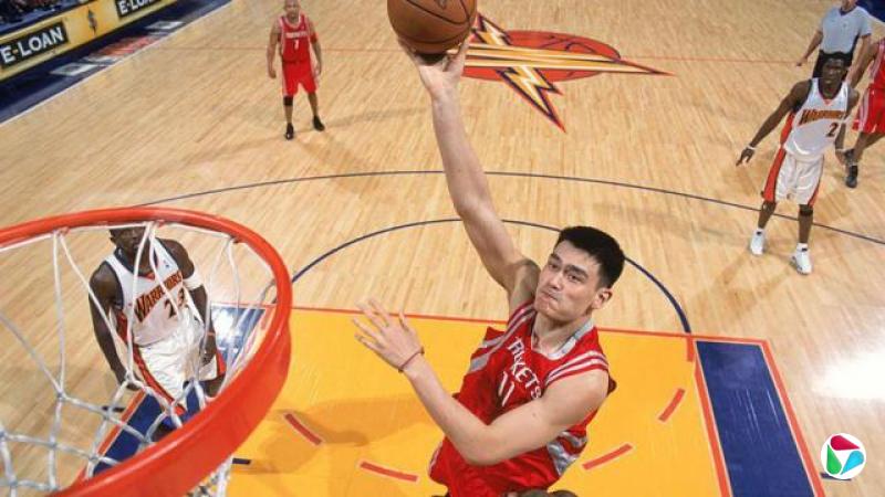 休士顿火箭队的姚明(11号)于2006年4月7日在加州奥克兰的奥克兰体育馆比赛中,对阵金州勇士队的阿多纳尔·福伊尔(31号)时出手投篮