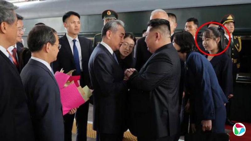 照片显示,金正恩在月台上与一名官员握手,周围簇拥着其他官员和身穿制服的警卫。他的女儿金主爱身穿黑色套装,站在他身后。