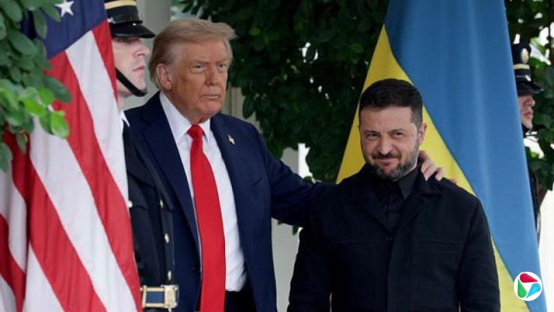 Trump puts his arm around Zelensky while they stand in front of flags of their respective countries. 