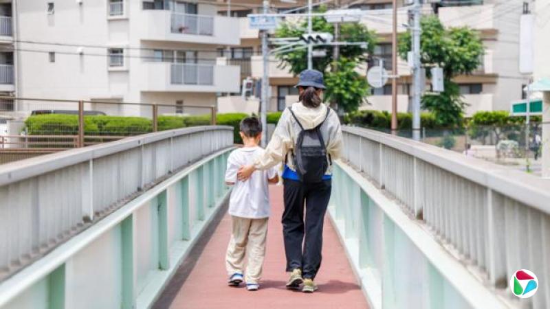 设计图片:日本神户一位女士(右)与男孩(左)并肩通过人行桥