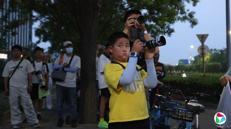 5月13日,北京的市民聚在一起观看美国总统特朗普的“空军一号”专机抵达北京首都机场。