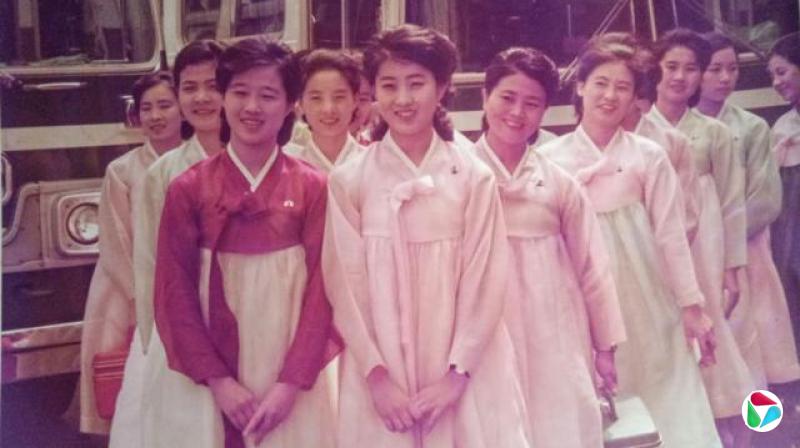 大约十几位身穿传统韩服的年轻女子站在车辆前。高英姬站在最前面,左侧。