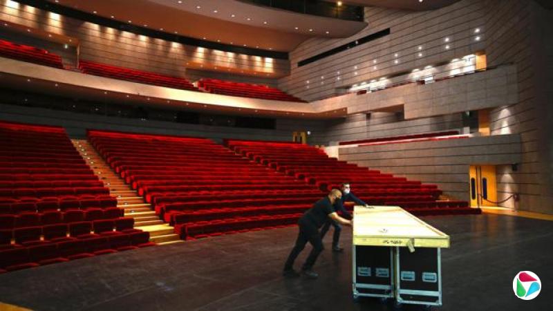 法国米卢斯一座剧院内后台工作人员在搬运器材与布景板(资料图片)